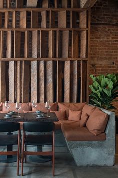 a living room filled with lots of furniture next to a wall covered in wooden planks