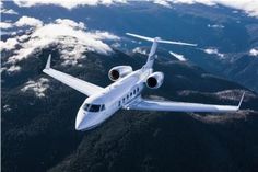 an airplane is flying over the mountains and clouds