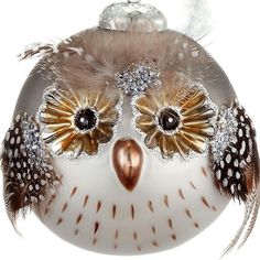 a glass ornament with an owl's face and feathers