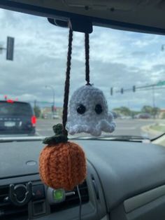 a stuffed animal hanging from the dashboard of a car