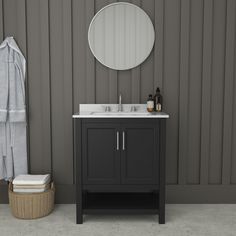 a bathroom with a sink and mirror next to a towel rack in front of a striped wall