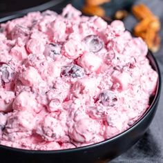 a black bowl filled with blueberries and other food on top of a gray table