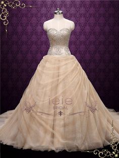 a wedding dress on display in front of a purple wall with gold trimmings