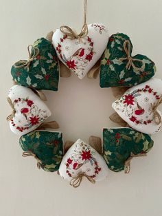 a wreath made out of christmas decorations hanging on a wall with twine ribbons around it