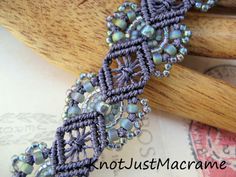 a close up of a bracelet on top of a piece of wood and some beads