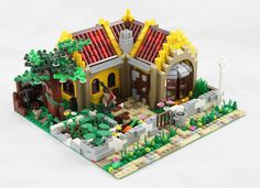 a lego model of a house with trees and bushes