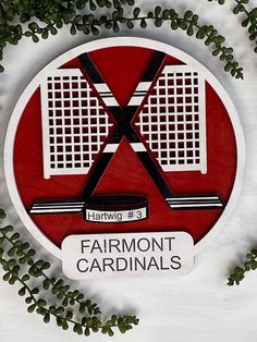 a red and white sign that says fairmont cardinals on it's side, surrounded by green leaves