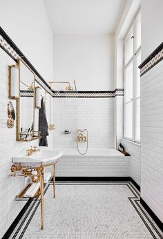 a black and white tiled bathroom with gold fixtures