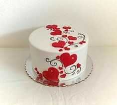 a white cake with red hearts on it