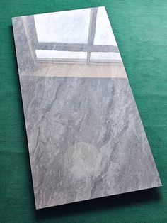 a large piece of marble sitting on top of a green floor next to a window