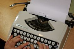 a person typing on an old fashioned typewriter