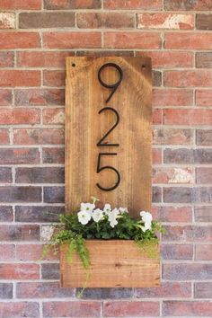 a wooden sign with the number twenty five on it and flowers growing out of it