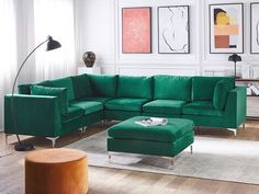 a living room with green couches and pictures on the wall above it, along with a coffee table