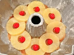 pineapples and cherries are arranged in the center of a cake pan with water running through it