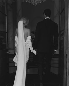 black and white photograph of bride and groom walking into the reception room at their wedding