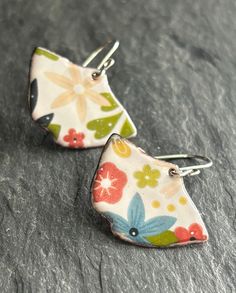 White enameled copper earrings with a bright,multicolored floral design. A sweet gift for a special gardener in your life. Approximate measurements: Enamel dangle: 1-1/2" x 7/8" Hang length: 1-3/8" Sterling silver earwires. To create these earrings, multiple layers of finely powered glass are fused to the copper using a torch flame. The floral design is added by firing a beautifully detailed decal onto the final layer of glass. We love making fun, boho inspired jewelry and hope you love wearing them. See more of our copper and enameled copper earrings & pendants here: www.etsy.com/shop/blueberrybayjewelry Multicolor Flower Earrings For Spring Gift, Colorful Earrings As Spring Gift, Colorful Spring Earrings As Gift, Colorful Spring Earrings For Gift, Colorful Spring Earrings For Gifts, Colorful Spring Gift Earrings, Unique Multicolor Flower Earrings Gift, Vintage Multicolor Earrings For Spring, Multicolor Vintage Earrings For Spring