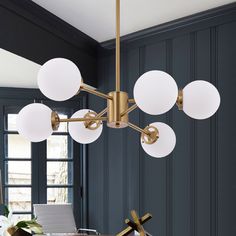 a modern chandelier hangs over a dining room table