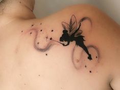 the back of a man's shoulder with a tattoo of a fairy on it