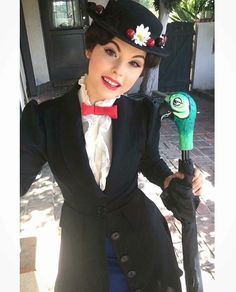 a woman in a top hat and coat holding an umbrella with a green monster on it