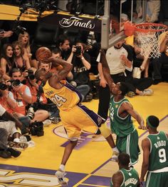 the basketball player is trying to dunk the ball in front of the other players