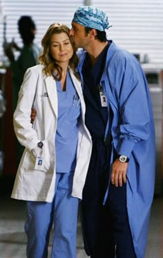 a man and woman in scrubs standing next to each other with their heads together