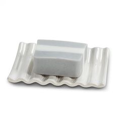 a white soap dish with two bars of soap on it's sides and one block of soap in the middle