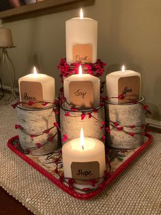 four candles are arranged in the shape of birch logs and wrapped with twine ribbons