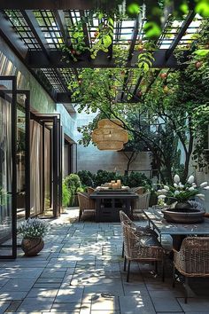 an outdoor dining area with wicker chairs and table surrounded by greenery on both sides