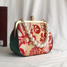 This Vintage Japanese bag with red floral pattern and emerald green velvet sides with kiss lock clasp frame is a wonderful example of Japanese style and the green sides adds a unique contrast making for an overall exquisite hand bag. ---------------------------- Product name / Ribbon Flower Color / as shown in the figure Fabric / Nishijinori , volvet Capacity / key, coin, face mask ,wallet .... Function / Top handle Size / Clasp frame 18cm* Length16cm X height15cm X width 9cm X 30cm pearl chain, Japanese Kimono Pattern, Handbag Ideas, Meaningful Gifts For Her, Emerald Green Velvet, Japanese Bag, Flower Handbag, Unique Handbags, Denim Handbags, Denim Flowers