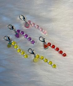 four different colored beads on a white fur covered surface with one bead in the middle