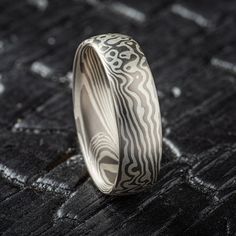 "* Price may vary depending on ring size, please inquire with us directly with your needed size for accurate pricing! Mokume Gane Band - Twist/Droplet Pattern in Droplet palette.  This ring is 6mm with low-dome profile and a satin finish. The ash palette consists of Palladium and Sterling Silver Mokume Gane Band Palette: Ash Pattern: Twist/Droplet Width: 6mm Size Shown: 9 Finish: Satin Profile: Low Dome Price does NOT include stones or setting fees. We care about customer service and would like to hear from you! Please contact us to help create your treasured item, we take your concerns and requests to heart and will work together to create your unique designs SPECIAL PRICING FOR SETS. CONTACT US WITH YOUR DESIRED WIDTHS FOR A QUOTE All Arn Krebs Mokume Gane Rings are CUSTOM and made-to-or White Teardrop Platinum Ring, Artisan Teardrop Wedding Jewelry, White Platinum Teardrop Ring, White Gold Jewelry With Engraving Option For Wedding, White Gold Wedding Jewelry With Engraving Option, Modern Silver Engraved Wedding Ring, White Gold Teardrop Promise Jewelry, Modern Etched Jewelry For Wedding, Silver Teardrop Ring With Polished Finish