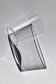 a clear glass vase sitting on top of a white table next to a black and white wall