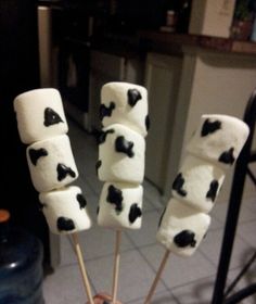 marshmallows with black and white spots on them are being held by someone's hand