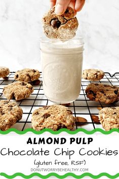 almond pulp chocolate chip cookies in a mason jar with a hand holding one cookie up to the camera