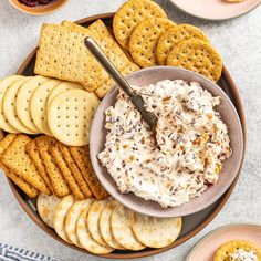 a bowl of dip surrounded by crackers and crackers