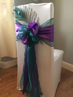 a chair decorated with purple, green and blue ribbons for a wedding or special event