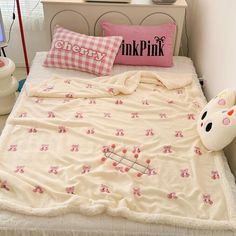 an unmade bed with pink and white pillows