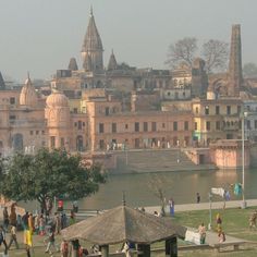 many people are walking around in front of an old building and water way with buildings on the other side