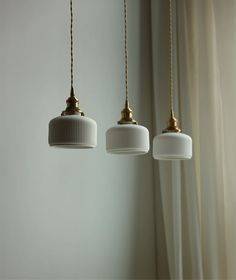 three lights hanging from the ceiling in a room