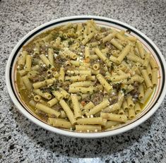 a bowl full of pasta with meat and cheese on it sitting on a counter top