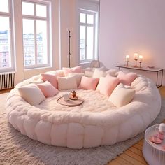 a living room filled with lots of furniture and pillows on top of a white rug