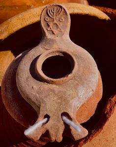 an old clay pot with a decorative decoration on it