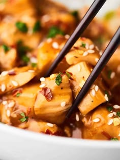 two chopsticks sticking out of some food in a bowl