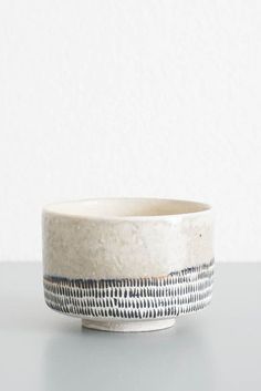 a white bowl sitting on top of a table next to a black and white object