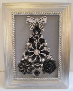 a christmas tree made out of black and white flowers in a silver frame with bows