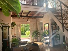 the inside of a house with stairs leading up to an open floor plan and potted plants