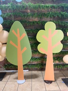 three paper trees are on display in front of balloons that look like they have been cut out