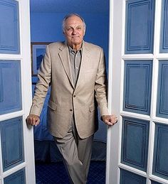 an older man in a suit is standing at the door