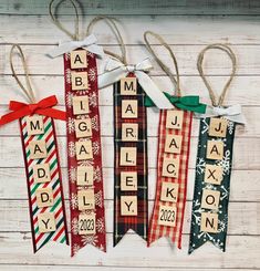 three christmas ribbon ornament hanging on a white wooden wall with the word merry written in wood block letters