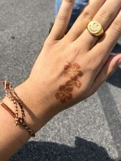 a woman's hand with a smiley face tattoo on her left wrist and ring